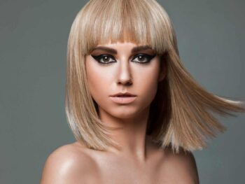 Model with a windswept platinum bob and smoky eye makeup