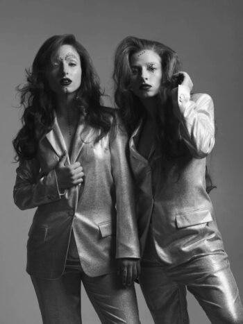 Two models in metallic suits, black-and-white portrait