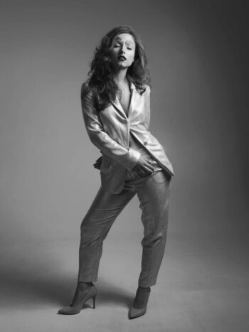 Model in a metallic suit and ankle boots, full-length black-and-white portrait