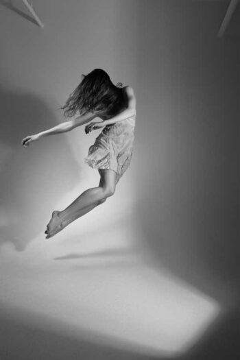 Dancer in mid-air with flowing hair, black-and-white photograph
