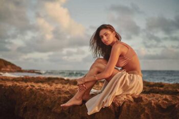 Schaeffer Studios Fashion Photographer Featuring Zorelys Lisboa Sitting on Rocks by Ocean
